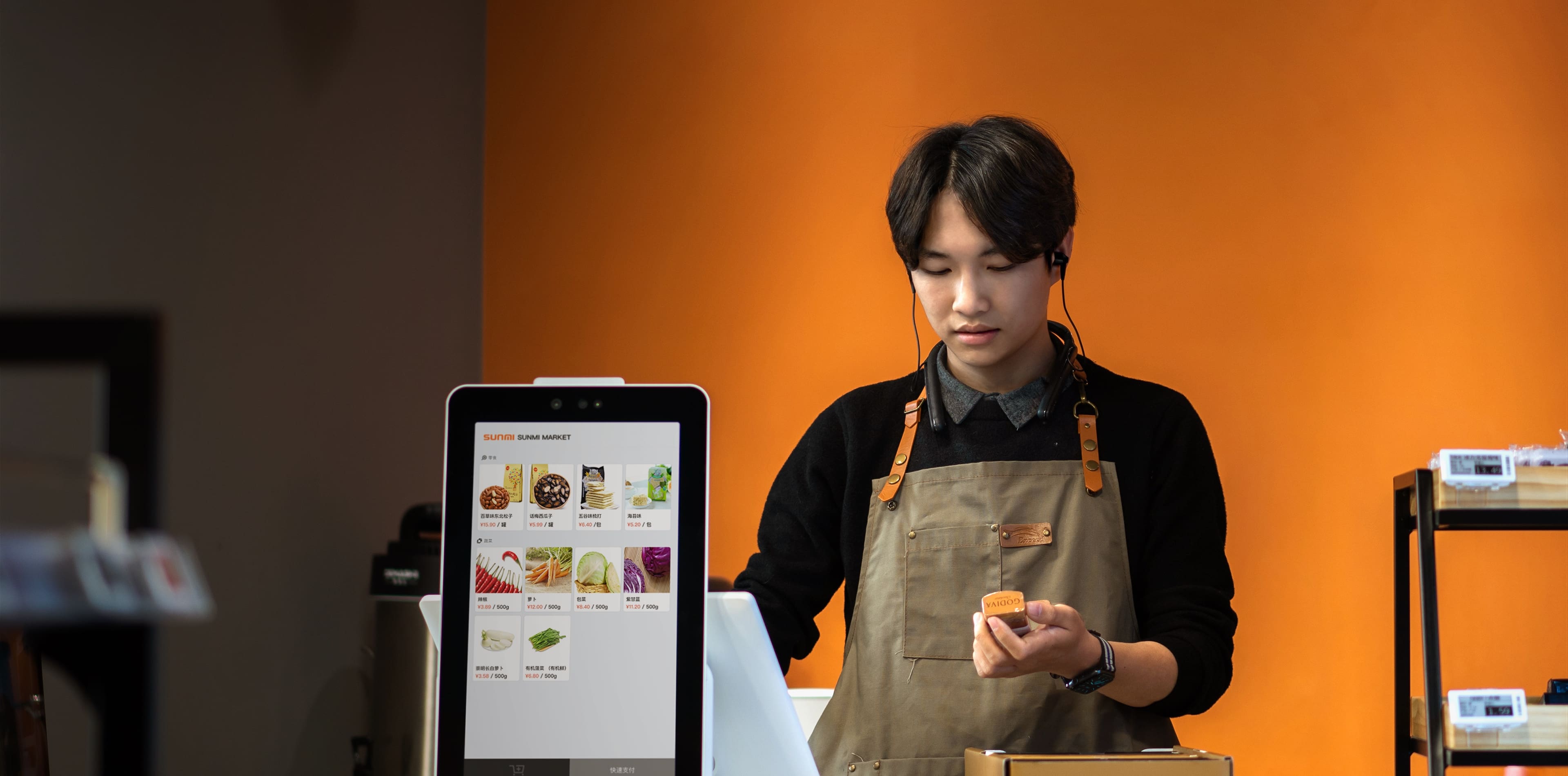 Shop staff member operating the Sunmi K2 Mini kiosk in attended mode at the counter