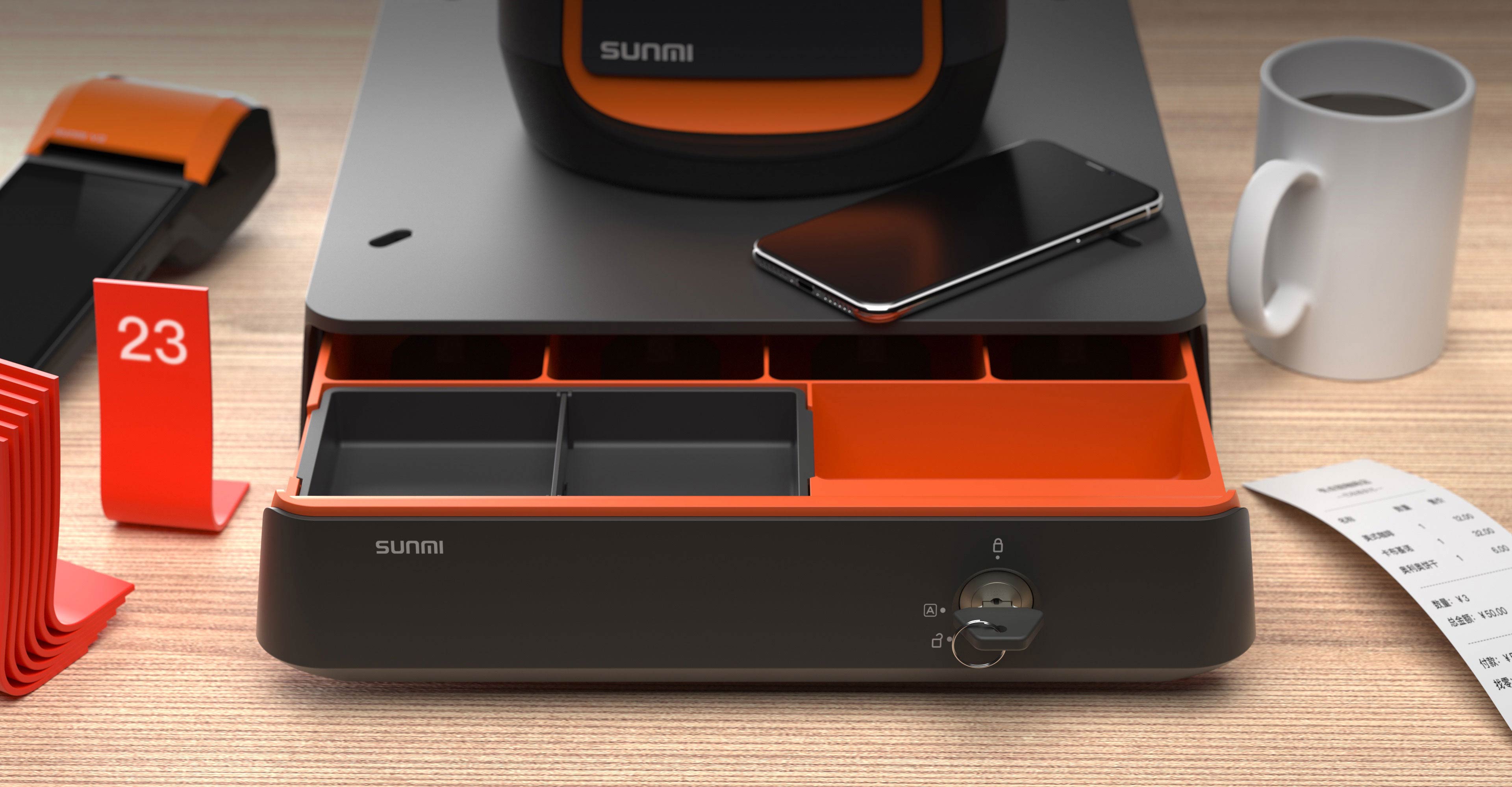 Sunmi Mini Cash Drawer open on a café counter under a Sunmi POS terminal, showing its orange inner trays beside a phone, mug and receipt